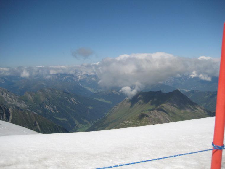 Vue vers l'Italie. En bas la verdure, contraste avec la neige du glacier